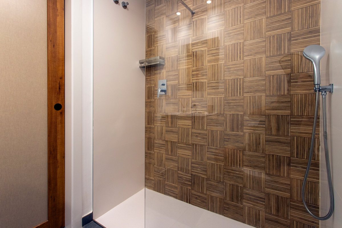 Bathroom with a spacious walk-in shower and a wall of wood-look tiles