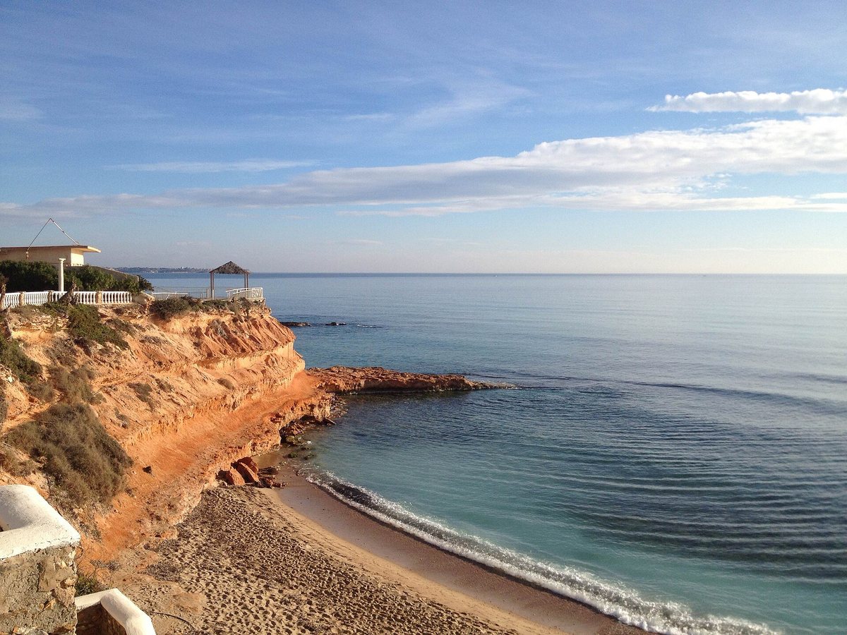 One of the Rocamar coves, with ochre rocks and clear water