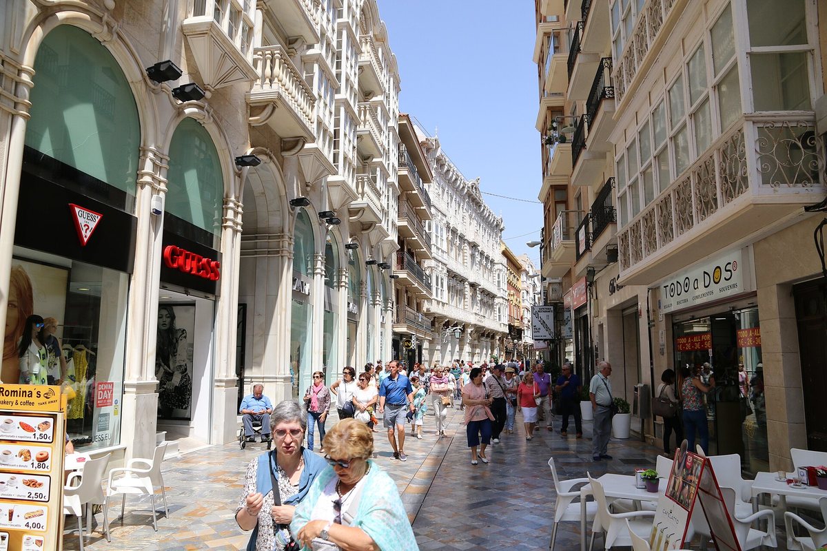 People strolling along Calle Mayor in Cartagena, lined with bay-windowed façades