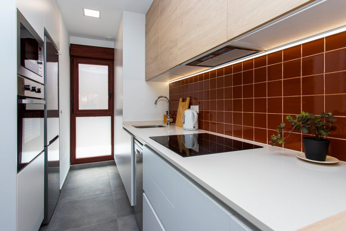 Kitchen with induction hob, built-in oven and microwave