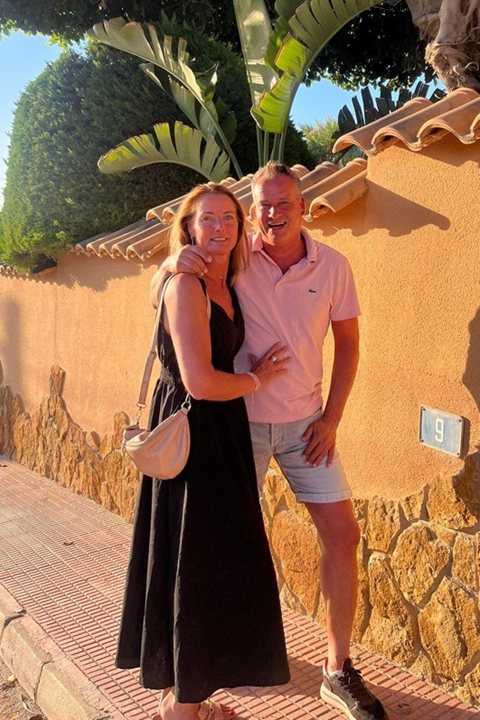 Linda and Ivry, the owners of Penthouse Pilar, at sunset against an ochre wall