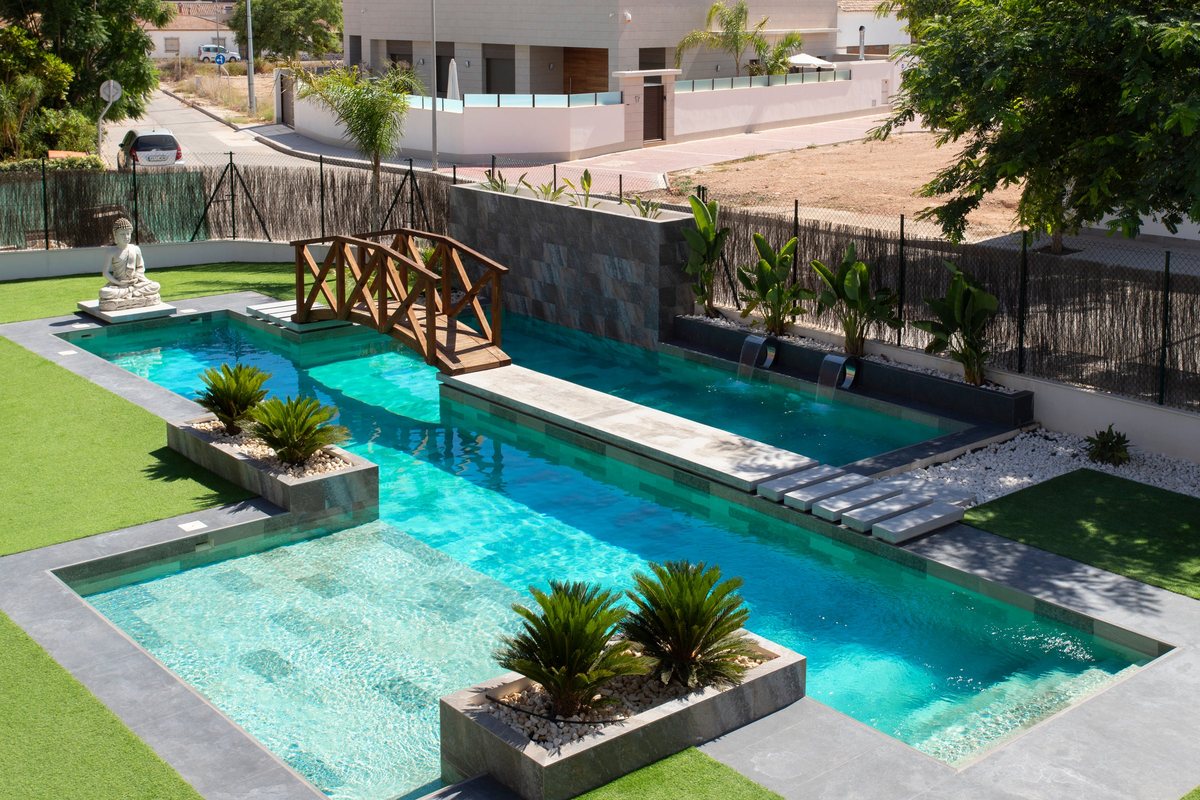 The shared pool and garden seen from above, with the wooden bridge and planters